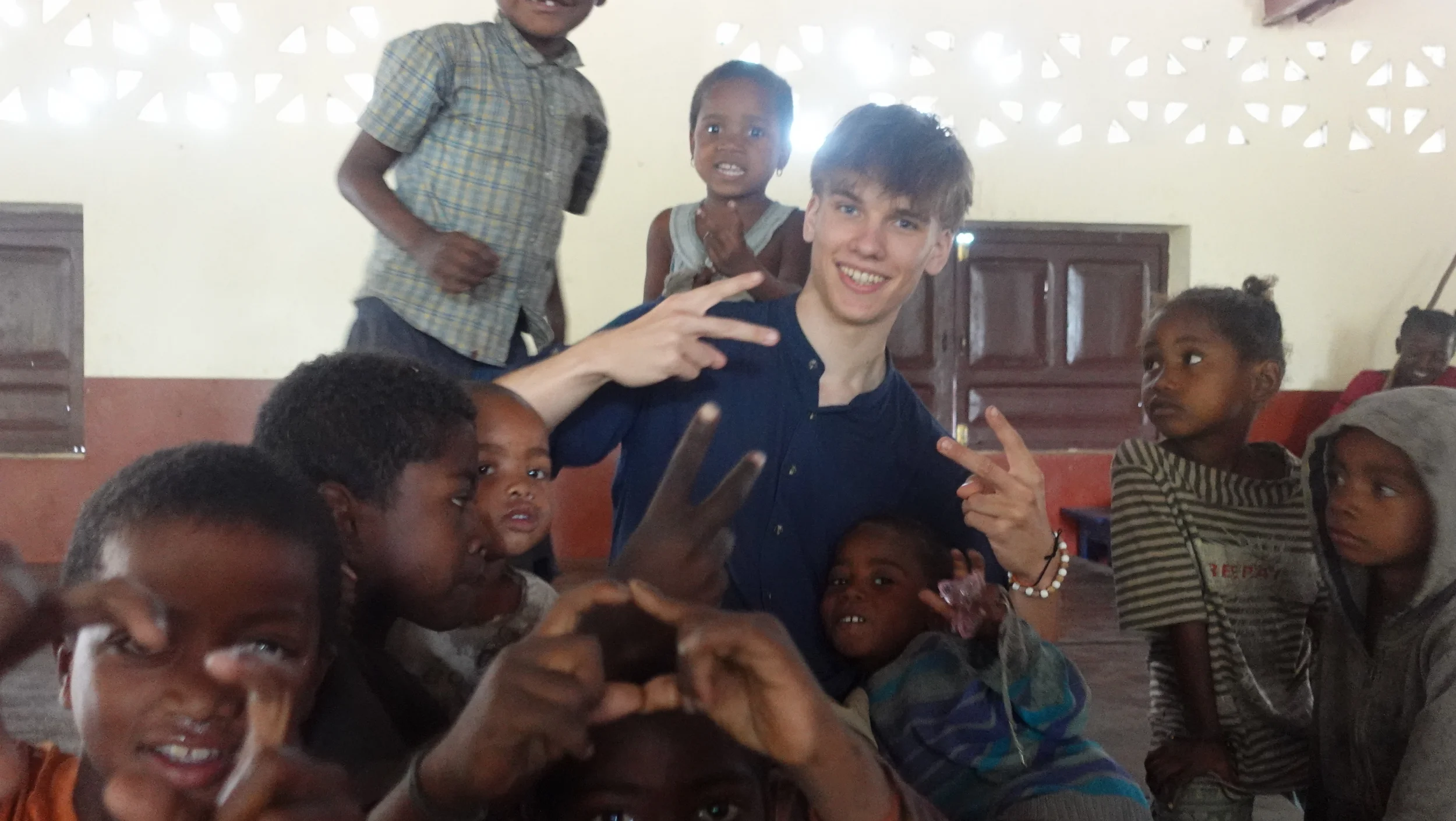 Sönke surrounded by smiling children at a school in Fort Dauphin