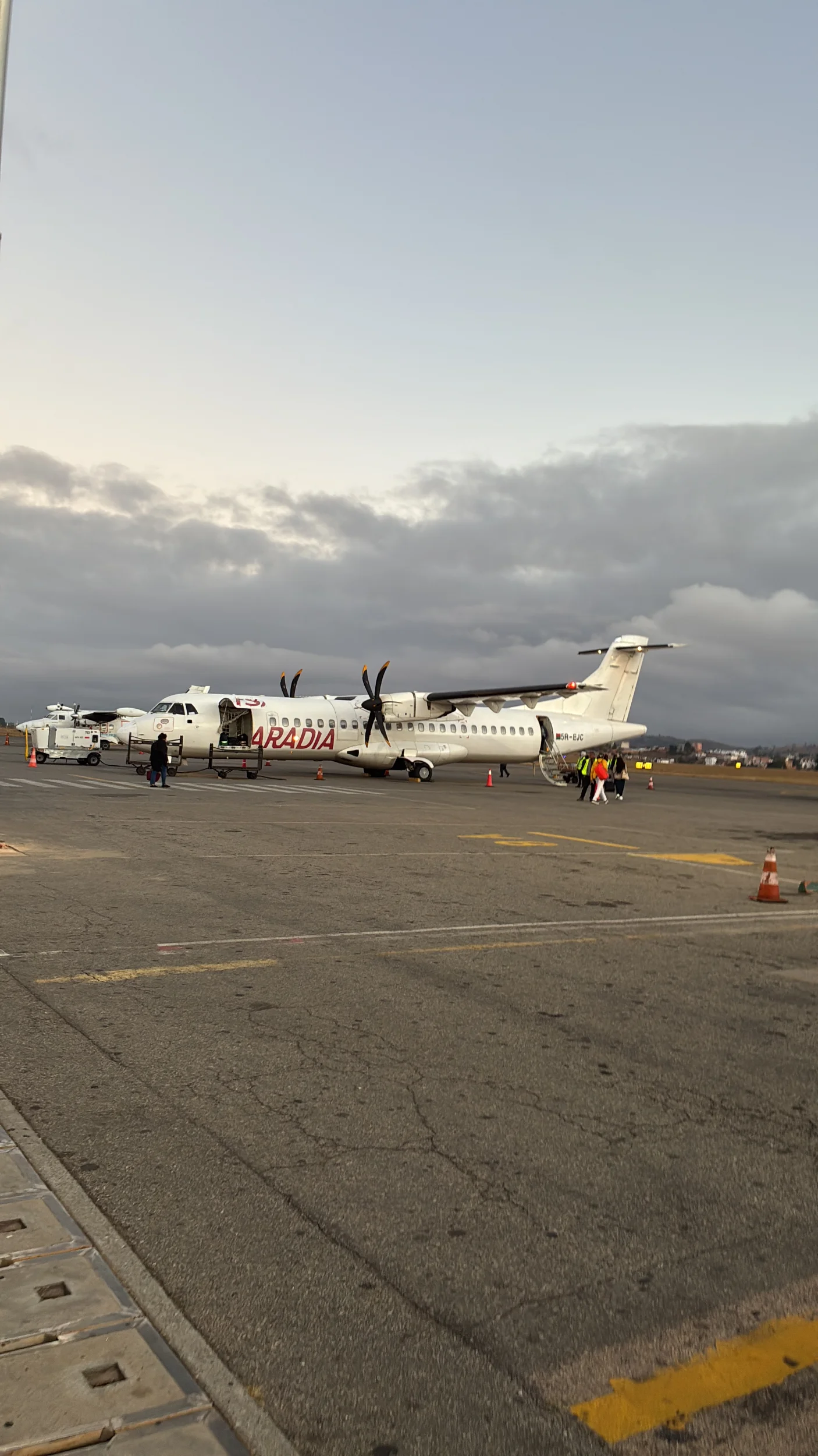 Passengers boarding an Aradia propeller plane on the airport tarmac